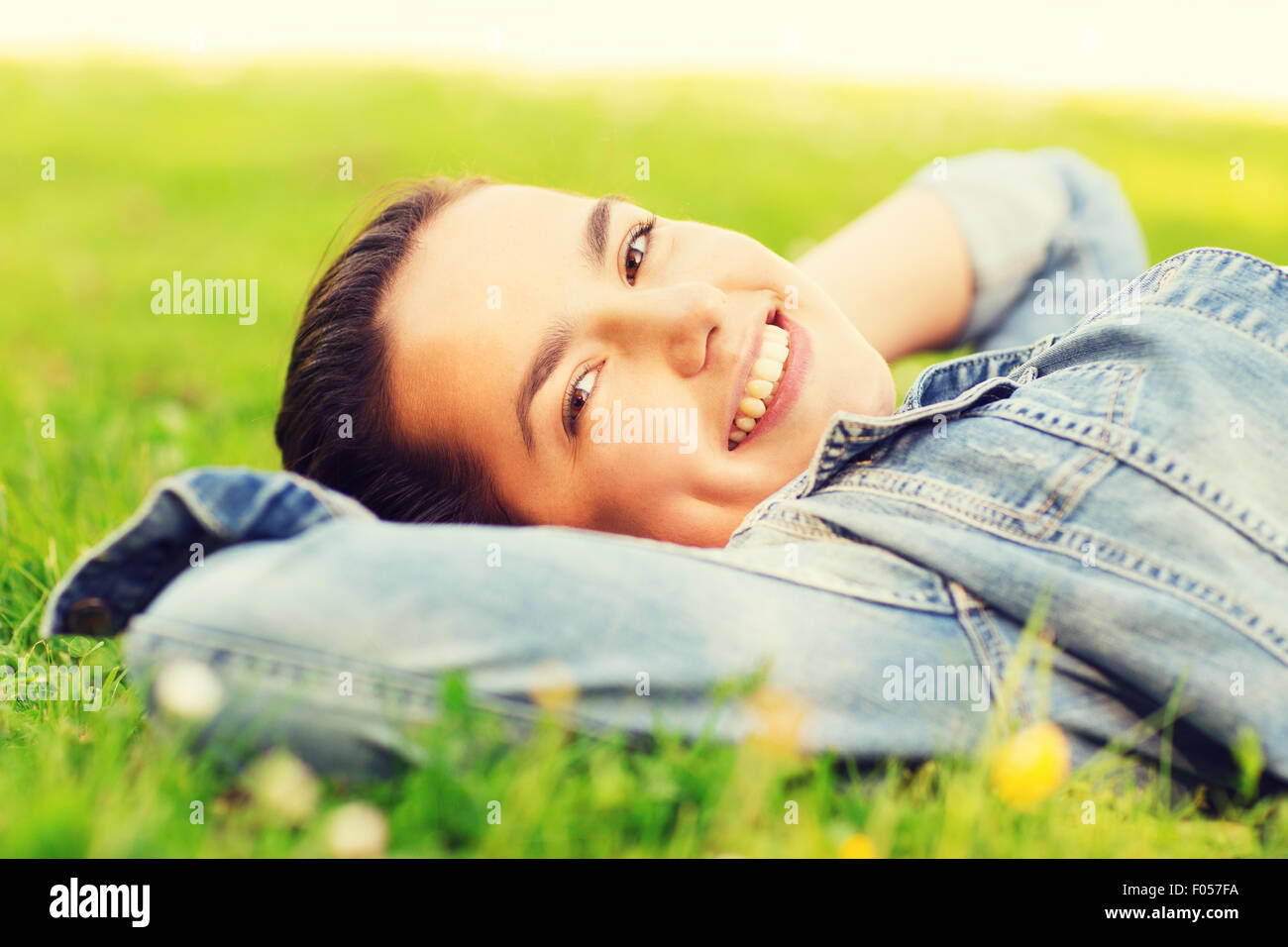smiling young girl lying on grass Stock Photo - Alamy