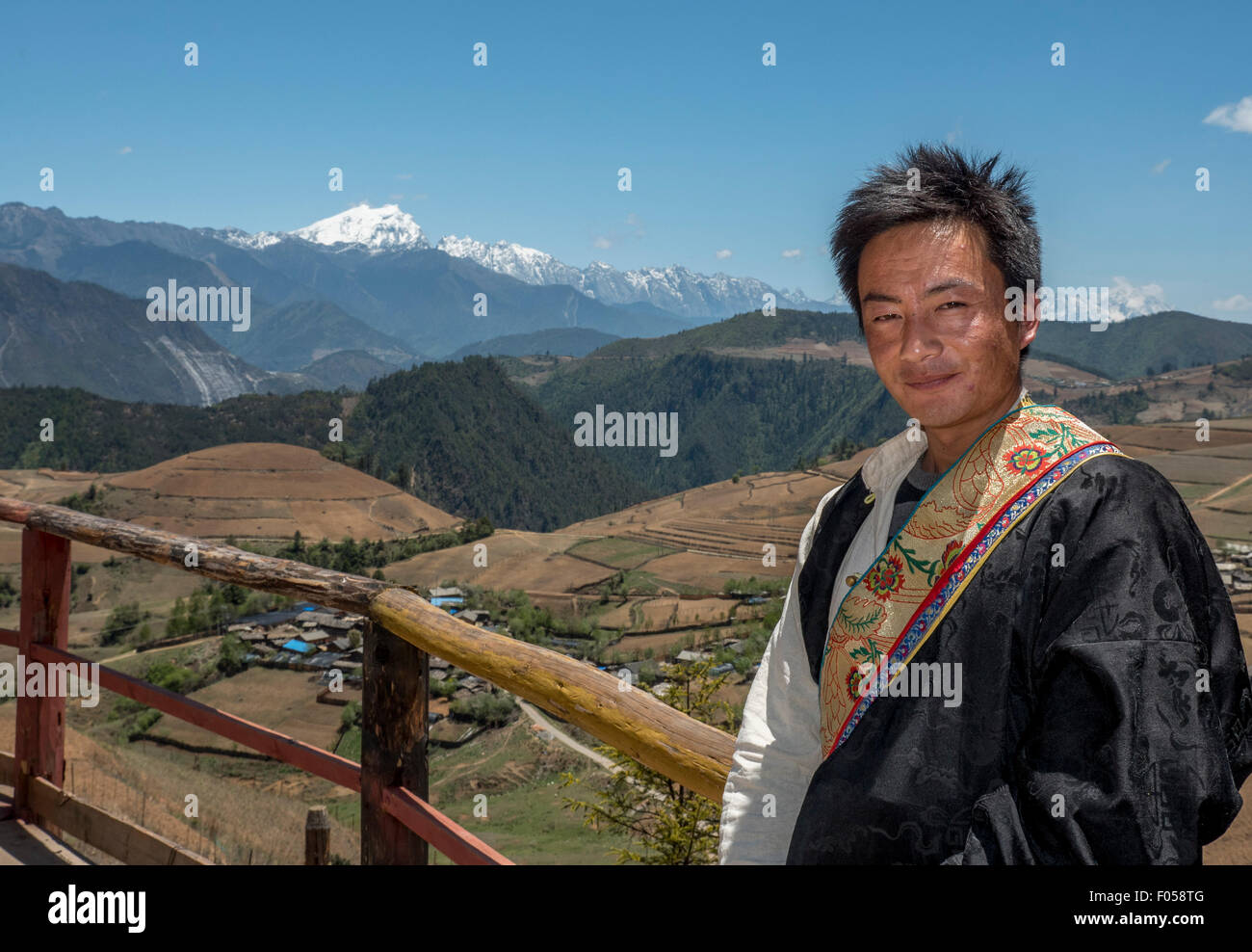 A Tibetan Man Dressed In Traditional Costume Poses In Front Of Meili Snow Mountain In Yunnan Province China Stock Photo