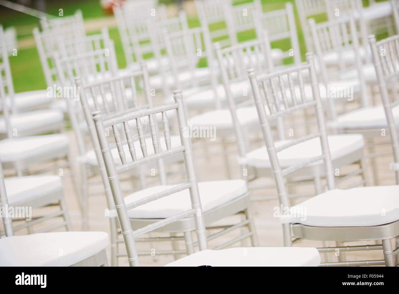 Prior to a wedding ceremony, endless white chairs wait for their guests. Stock Photo