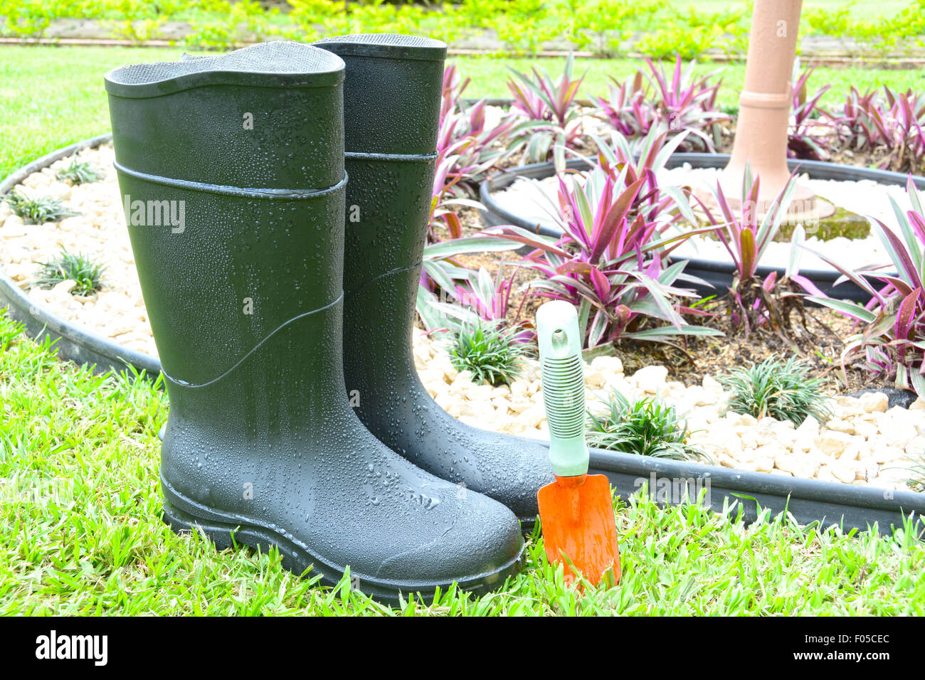Black rubber boots and gardening tool in a house garden Stock Photo Alamy