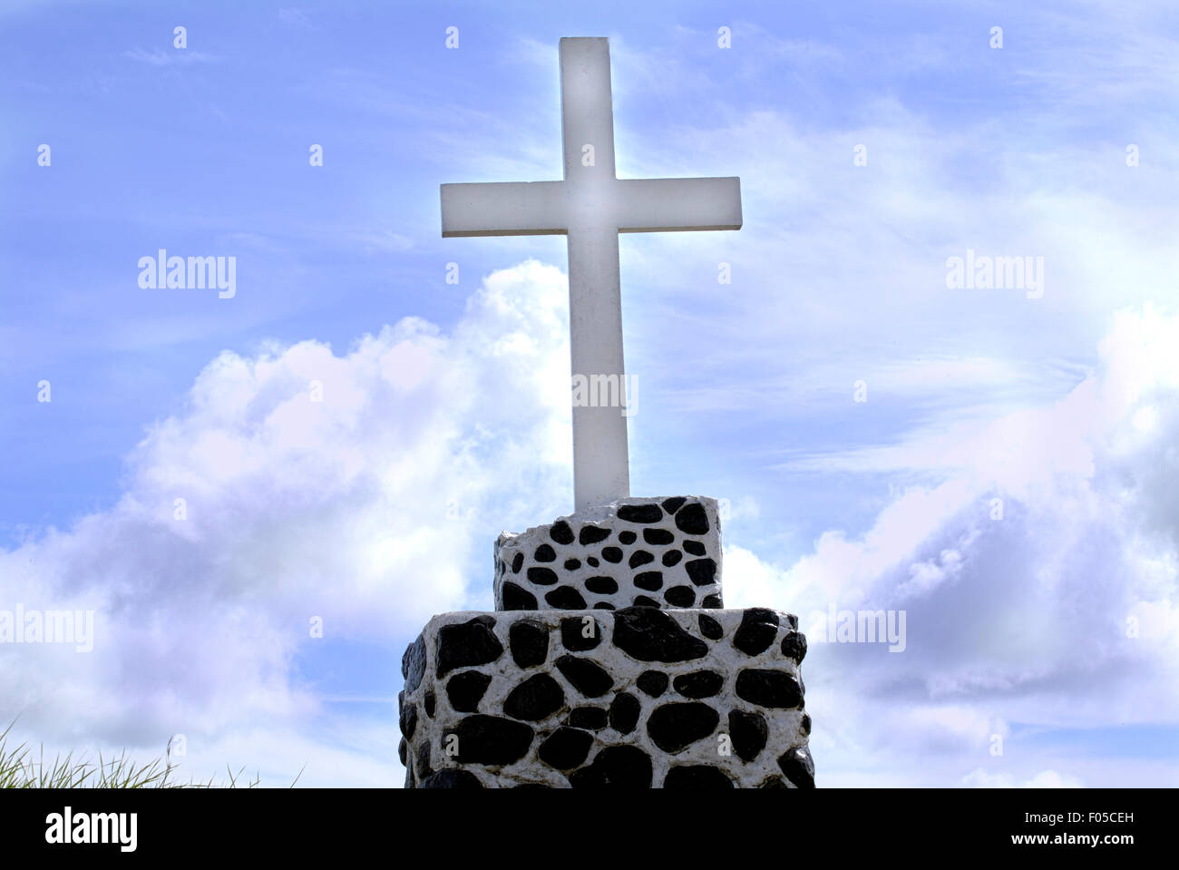 Concrete Christian cross with a blue sky in the back Stock Photo