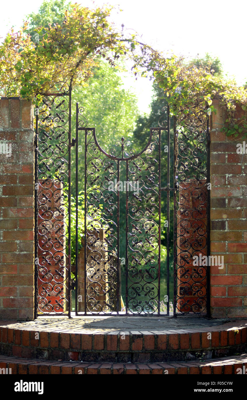 An ornate iron garden gate and steps. Stock Photo