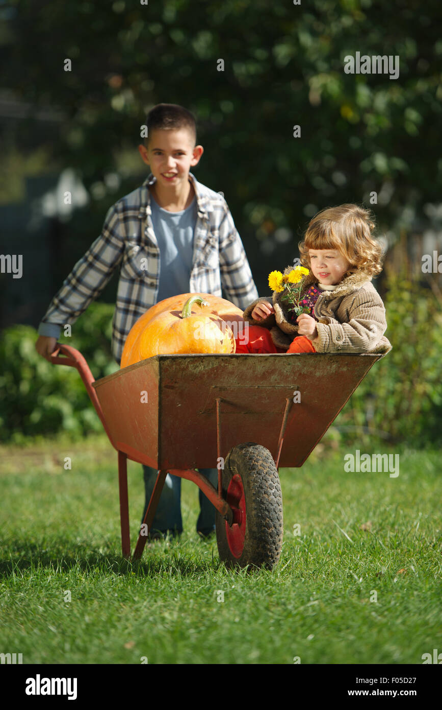 girl and boy with pumpkins in the garden Stock Photo - Alamy