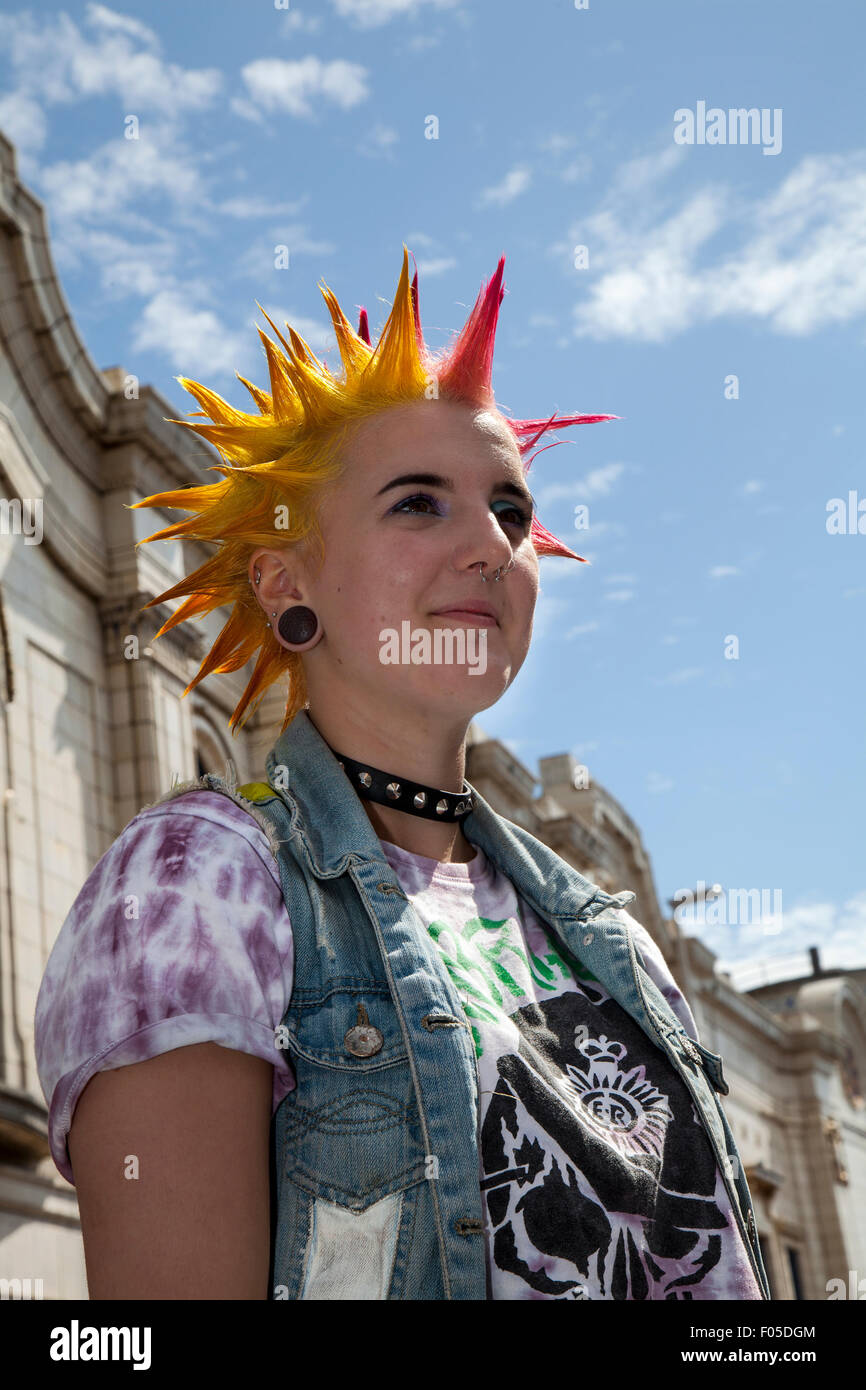Punks with mohican dyed yellow & red hair, punk rockers Mohawk Liberty spikes mohican hairstyle at Blackpool, Lancashire, UK.Aug, 2015. Punk Rebellion festival at The Winter Gardens. A clash of cultures at the famous seaside town of Blackpool as punks attending the annual Rebellion festival at the Winter Gardens come shoulder to shoulder with traditional holidaymakers. Stock Photo