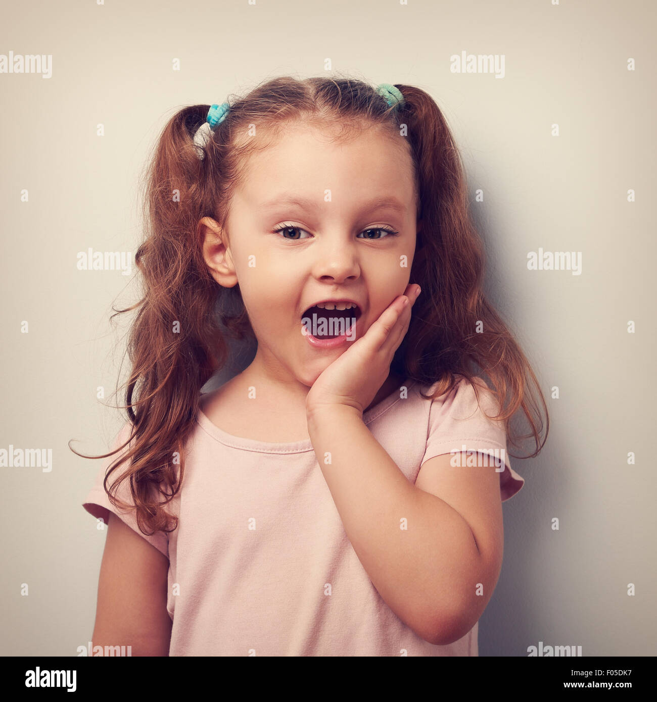 Surprising fun girl looking with open mouth. Vintage closeup portrait Stock Photo