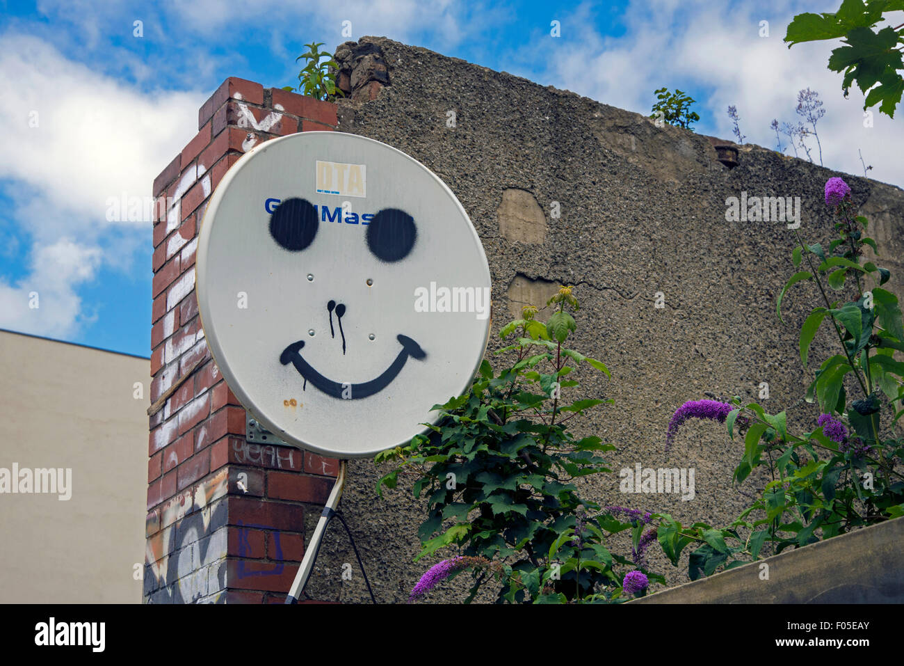 A smiley face painted on a satellite receiver dish. Stock Photo