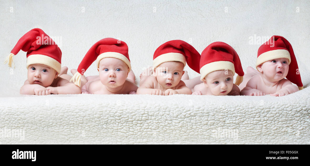 babies with santa hats on bright background Stock Photo