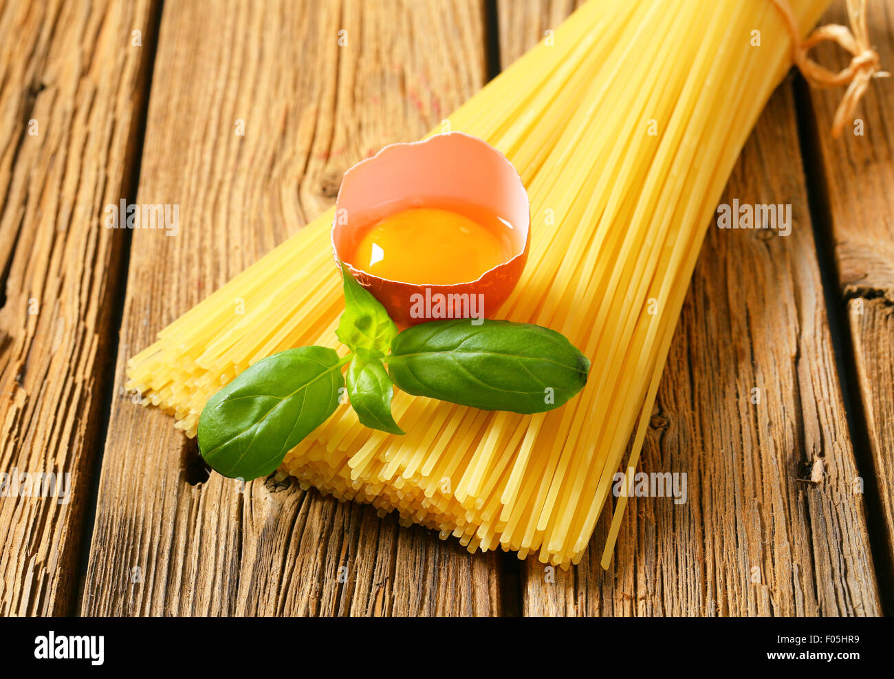 Bundle of spaghetti and raw egg Stock Photo