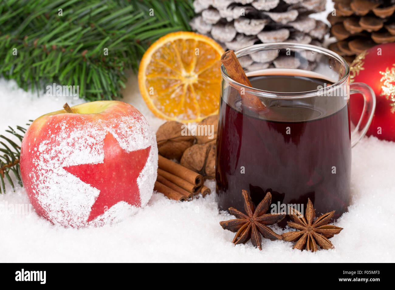 Winter apple fruit and mulled wine alcohol drink on Christmas decoration with snow Stock Photo