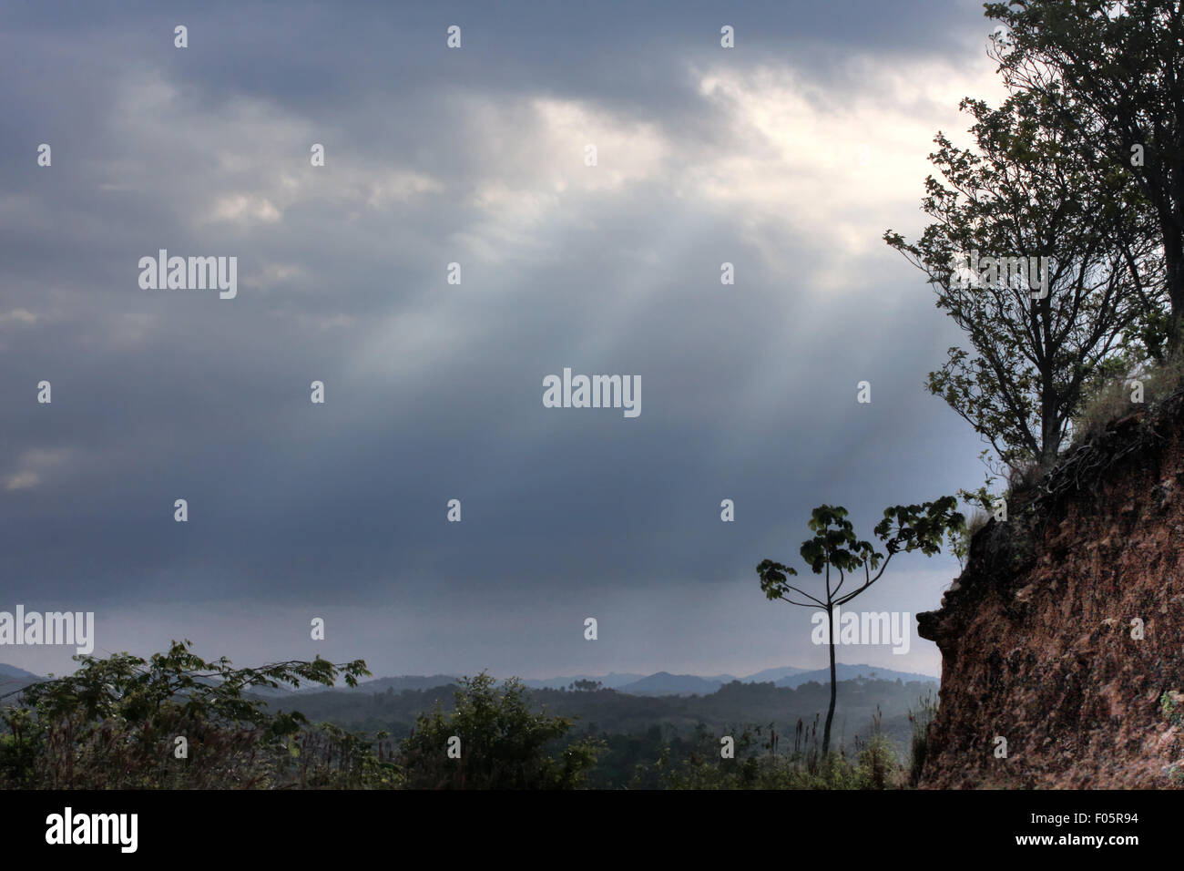 Sun beams shining through storm clouds in the countryside of Panama Stock Photo