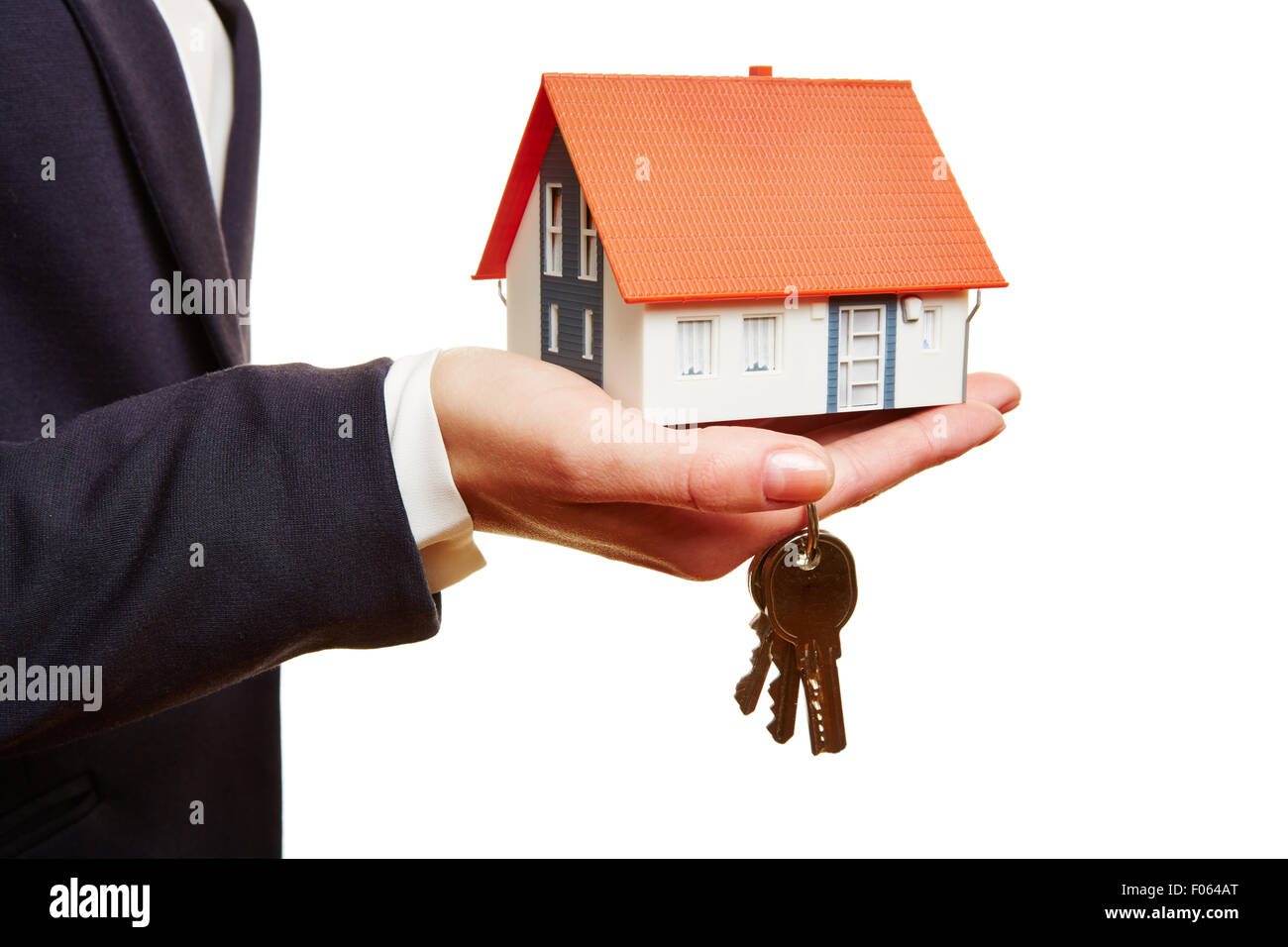 Real estate agent holding small house and keys in her hand Stock Photo ...