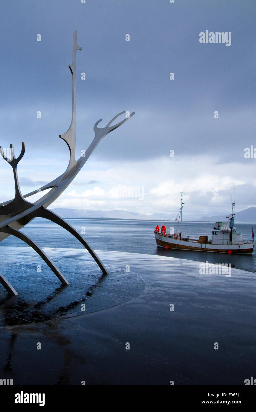 A ship passes near the Sun Voyager (Icelandic: Sólfar) sculpture by Jón Gunnar Árnason in Reykjavík, Iceland Stock Photo
