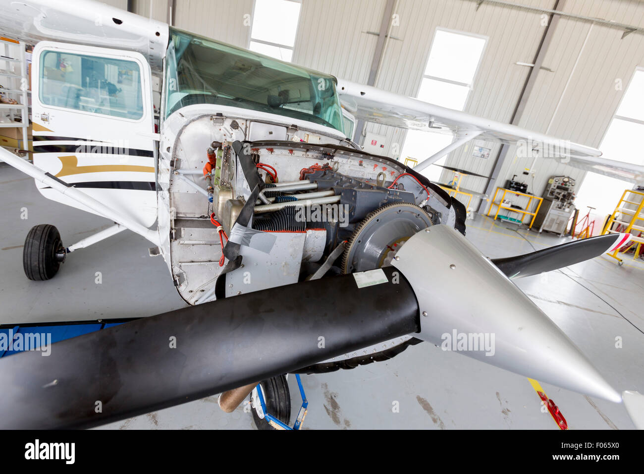 Small two-seated propeller airplane is being repaired in a hangar at ...