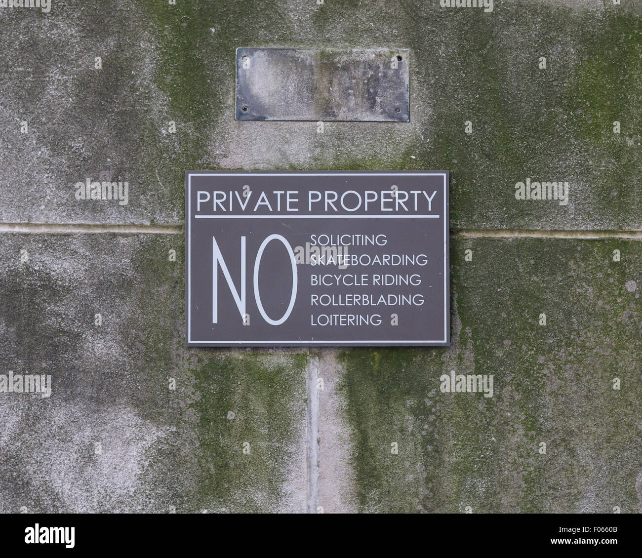 Private property sign announcing the rules on a mossy limestone wall. Stock Photo
