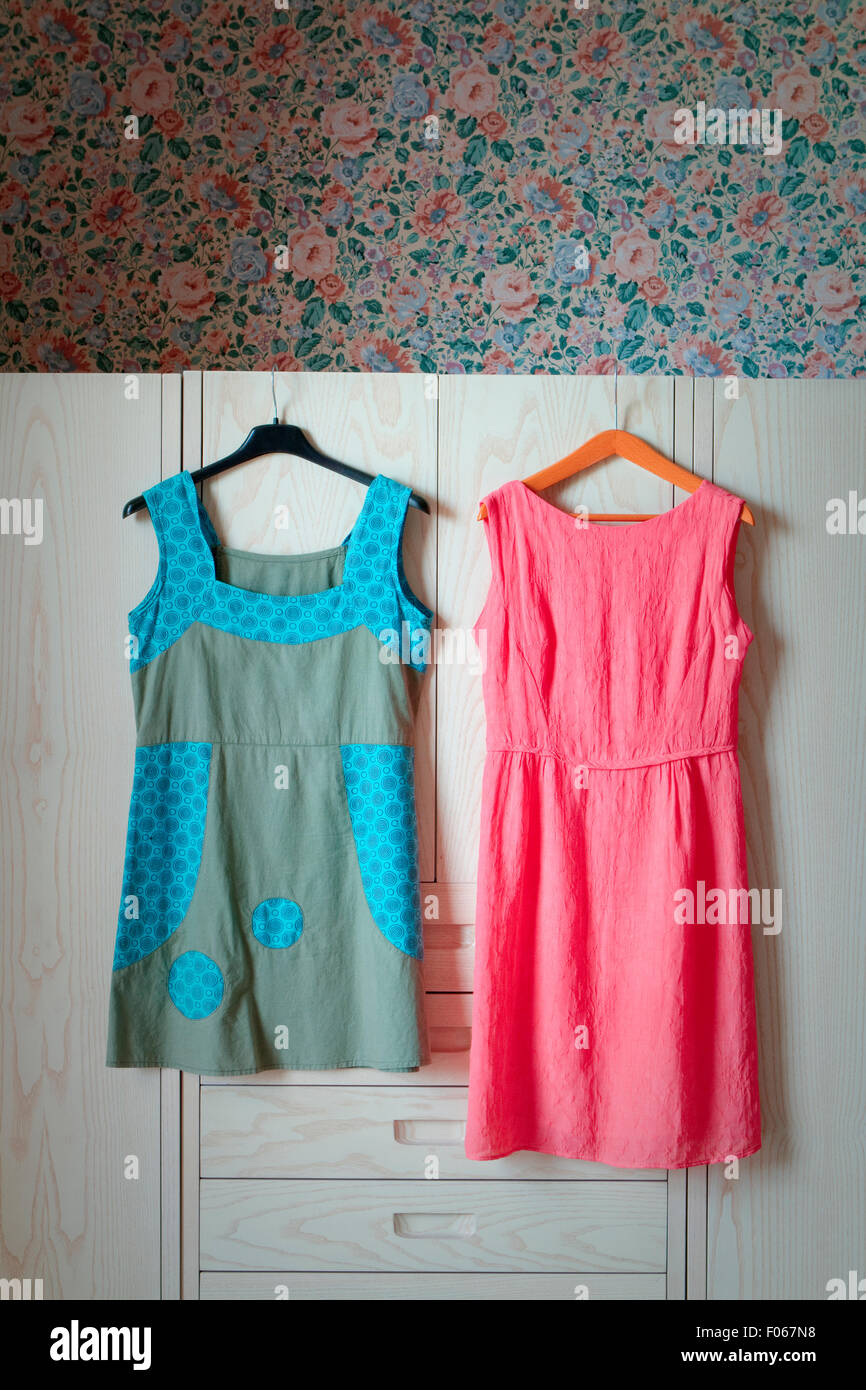 Two woman dresses hanging from a wardrobe Stock Photo