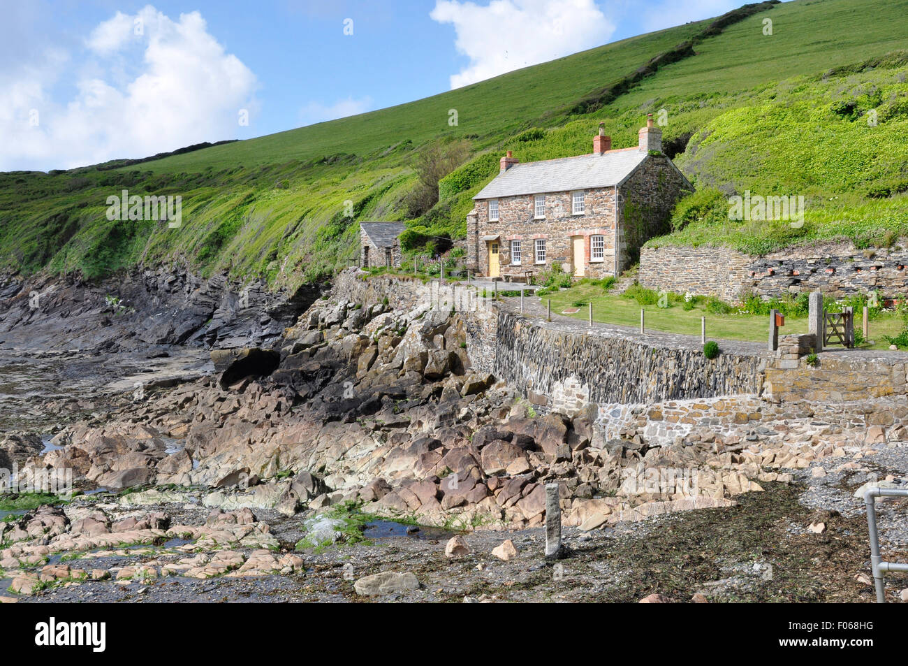 North Cornwall - Port Quin - traditional slate +stone built cottages set above rugged  shoreline - backdrop steeply rising hills Stock Photo