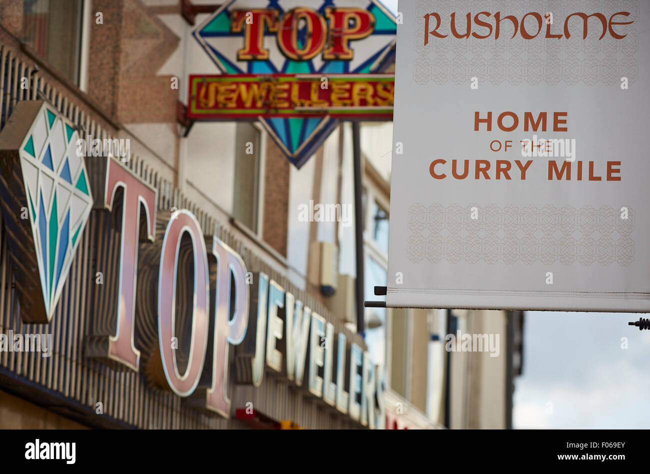 Rusholme A34 curry mile in Manchester Uk   First bus 42 route  cycling on road bike cyclist Shop shopping shopper store retail s Stock Photo