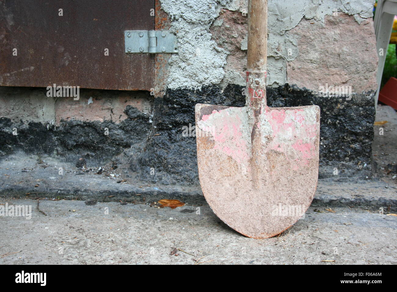 Rusted shovel by a stone wall. Stock Photo
