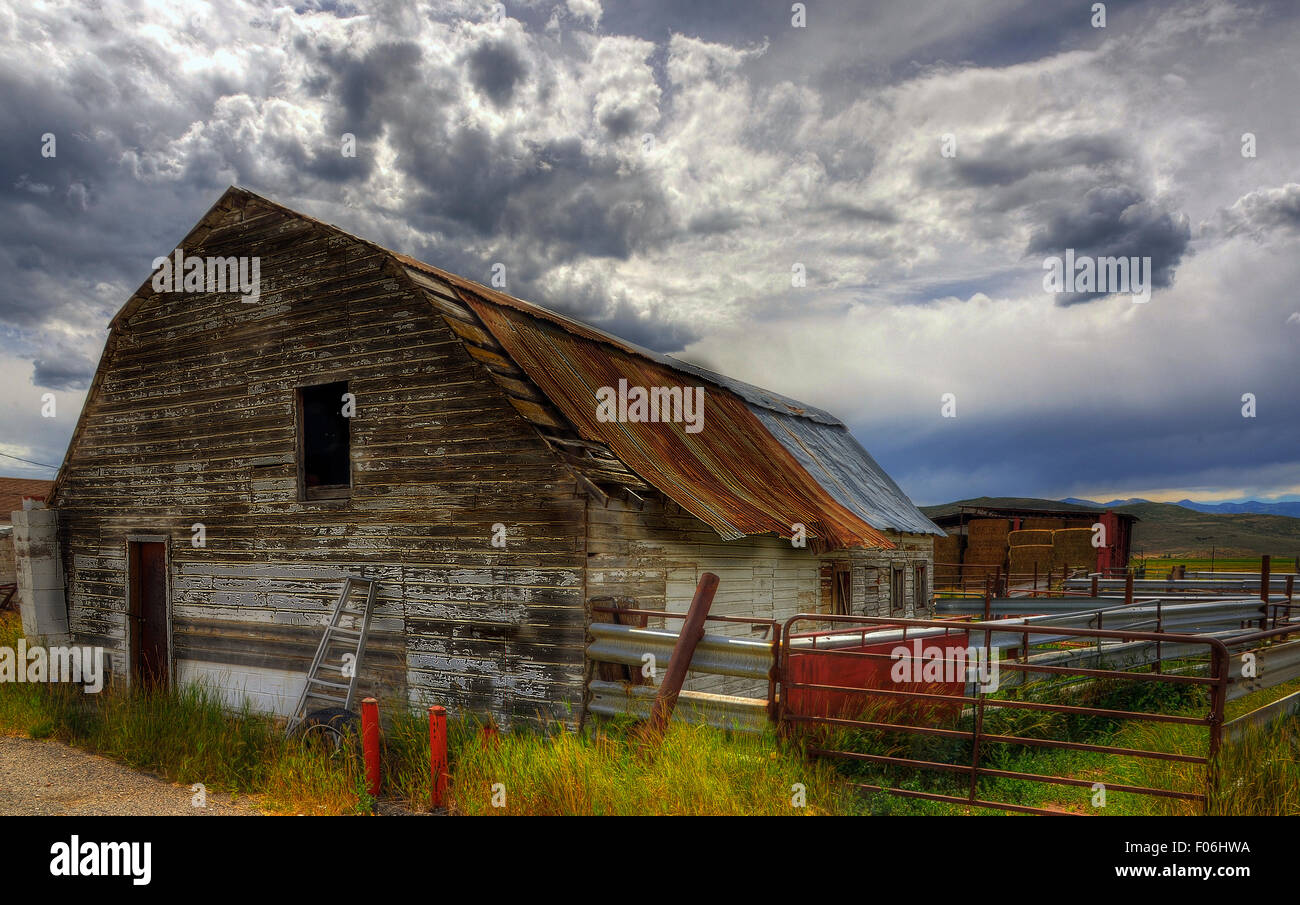 Ancient barn with a rusting roof under the leading clouds of an on ...