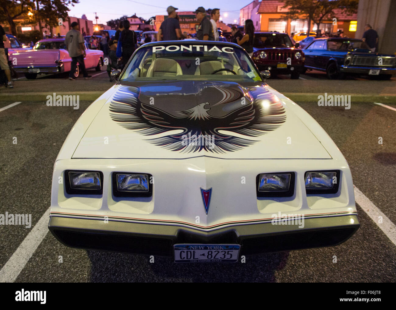 Bellmore, New York, USA. 7th August 2015. A white 1980 Pontiac Turbo-Trans Am, with large eagle decal sticker on hood, is displayed at the Friday Night Car Show held at the Bellmore Long Island Railroad Station Parking Lot. On side of car a decal states 'Official Pace Car, Torbo-Trans Am, 64th Annual Indianapolis 500 Mile Car Race on May 25, 1980.' Hundreds of classic, antique, and custom cars were on view at the free weekly show, sponsored by the Chamber of Commerce of the Bellmores. Stock Photo