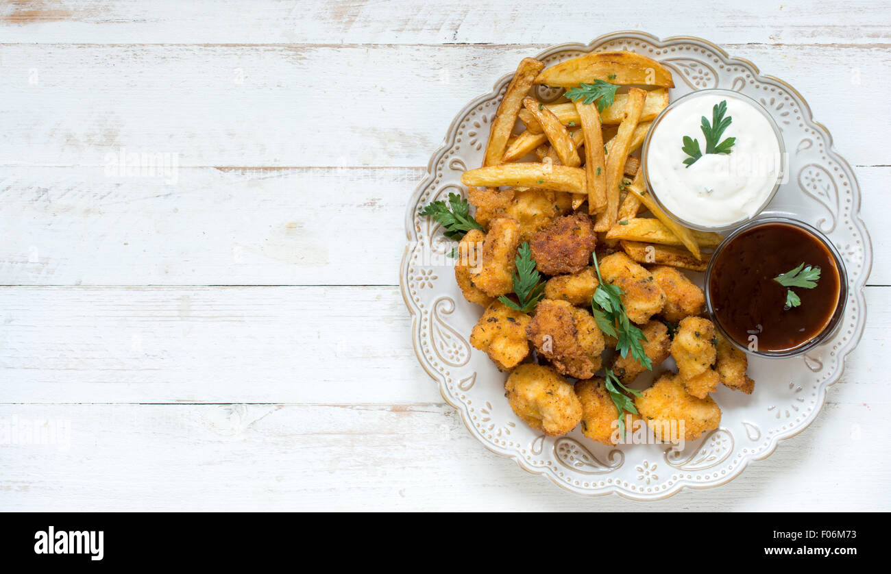 Served plate with fried chicken nuggets and french fries,blank space on the left side Stock Photo