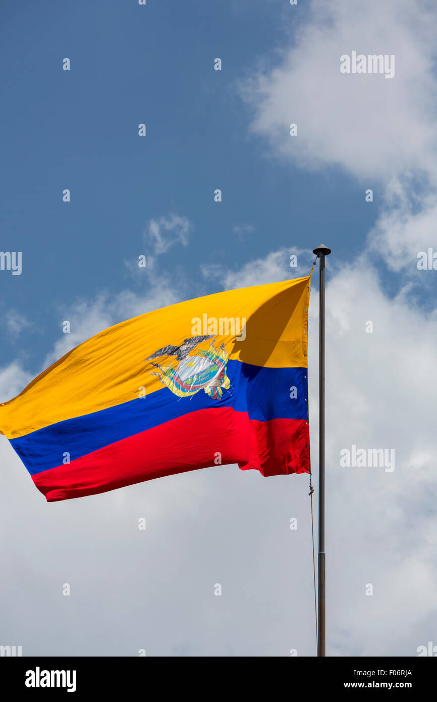 Large Ecuador flag waving in Quito Presidential Palace with a cloudy blue sky in the background. Stock Photo