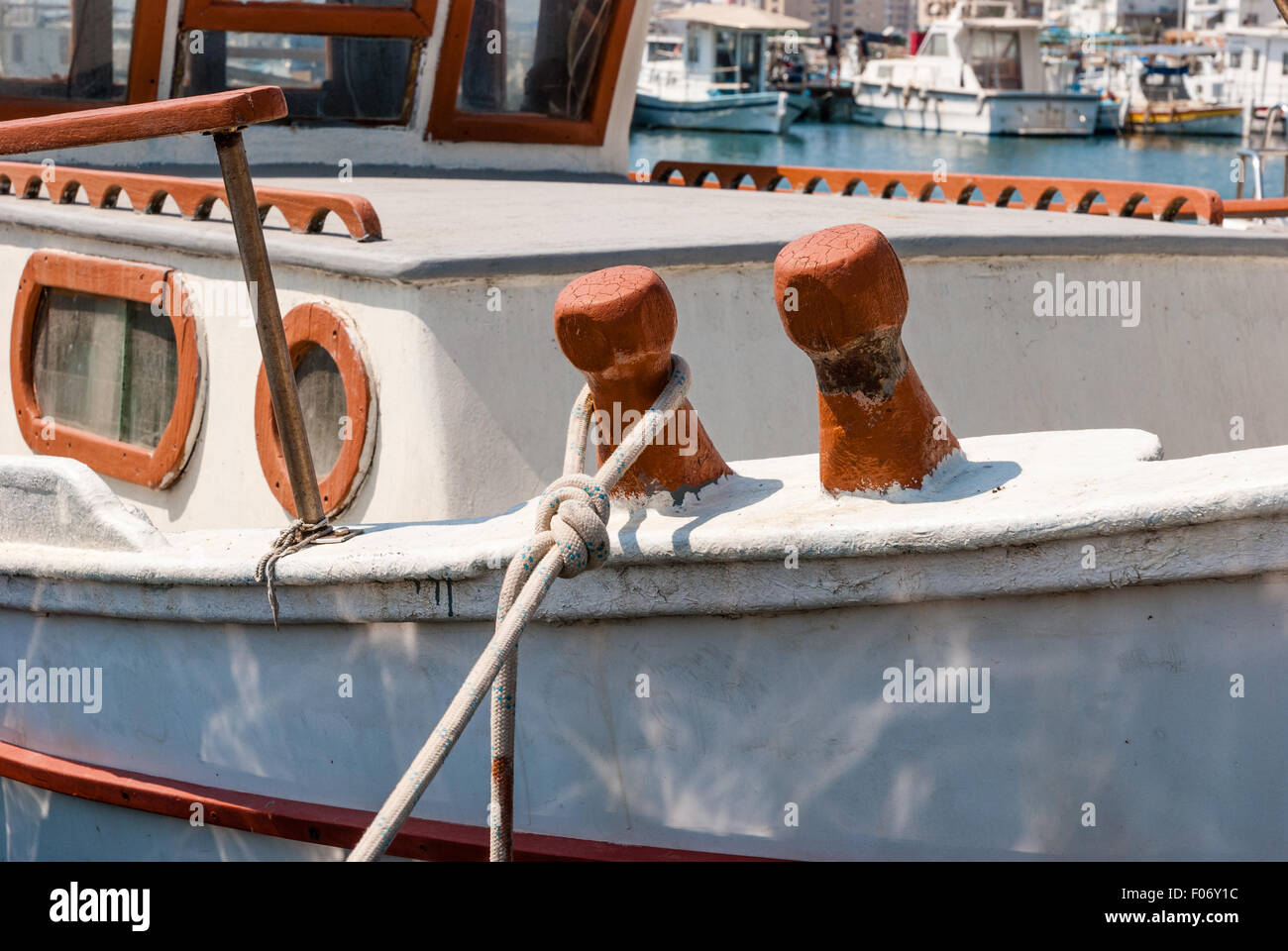 old wooden fishing boat cleats with rope wrapped around. Closeup Stock