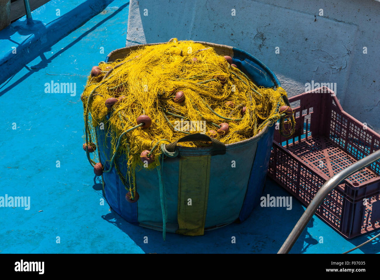 Colorful fishing nets and floats in basket on deck after fishing Stock