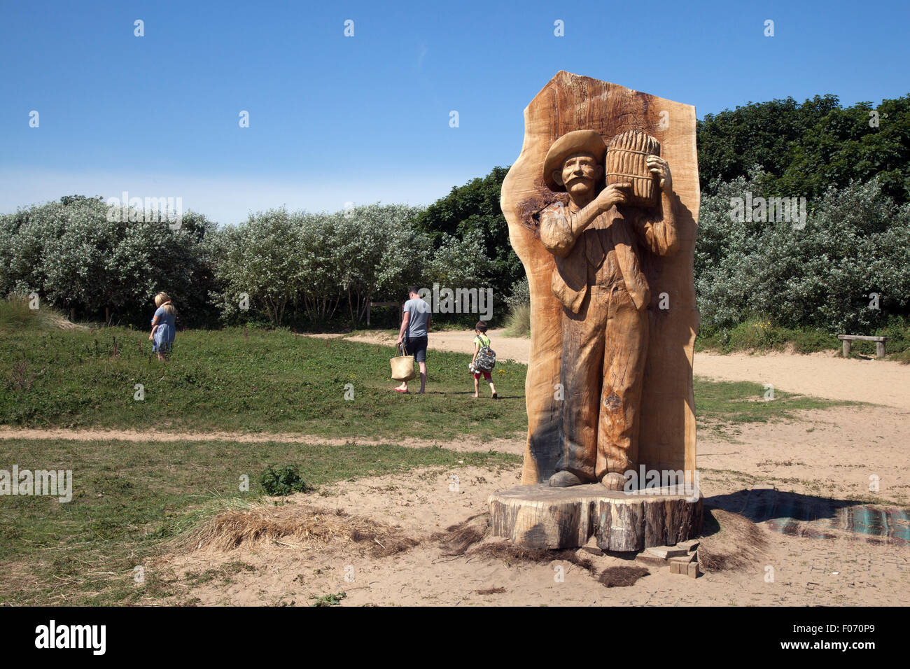 Asparagus farmer wooden statue in Freshfield, Formby, Merseyside, UK. August, 2015.  Local artist Simon Archer's sculpture   Stock Photo
