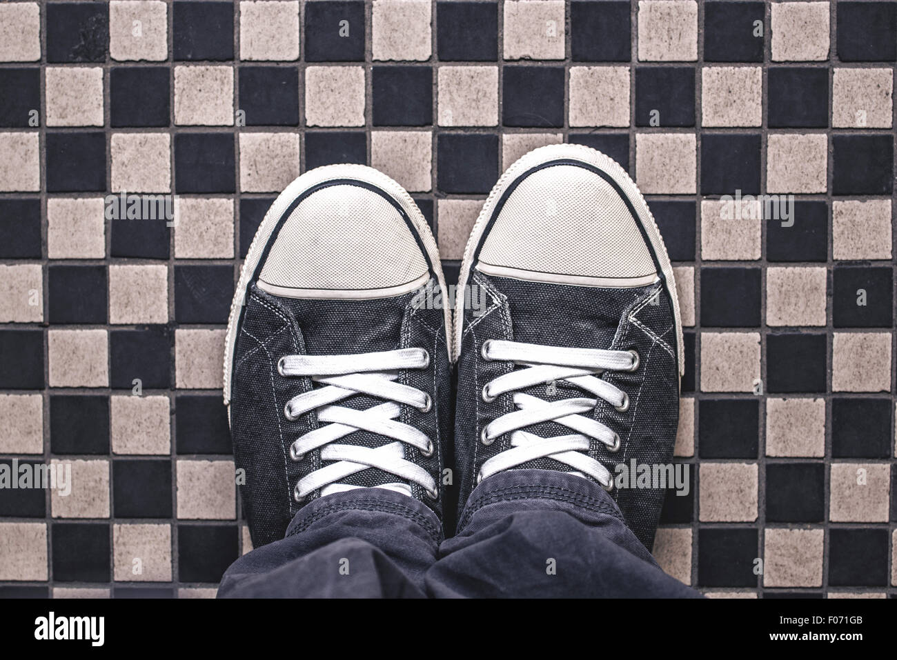 Gray Sneakers on Checkered Pattern Pavement, Top View, Overhead Shot of Man Standing on Street, Urban Lifestyle Concept Stock Photo