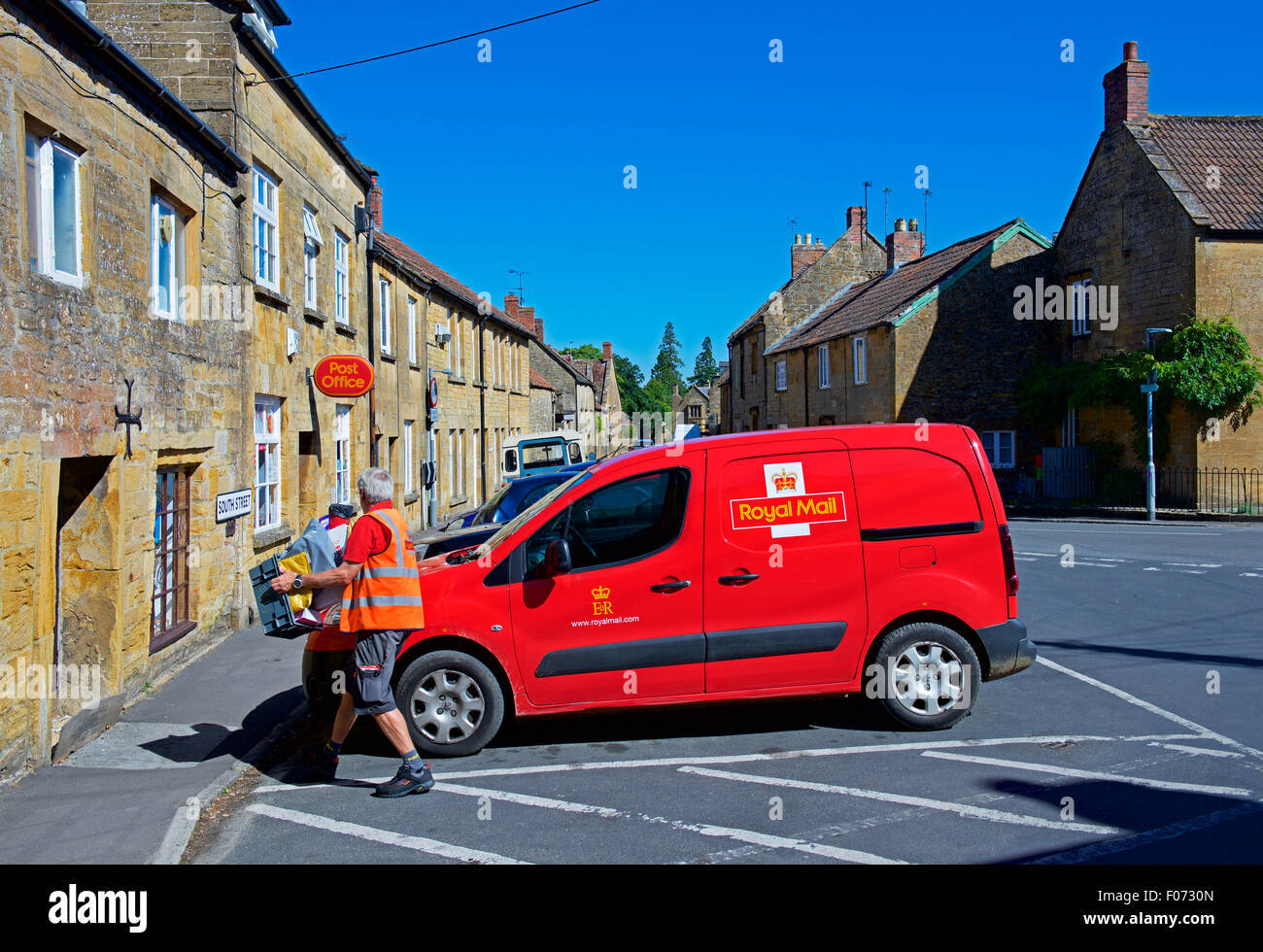 Postman taking parcels into Post Office in the village of Montacute