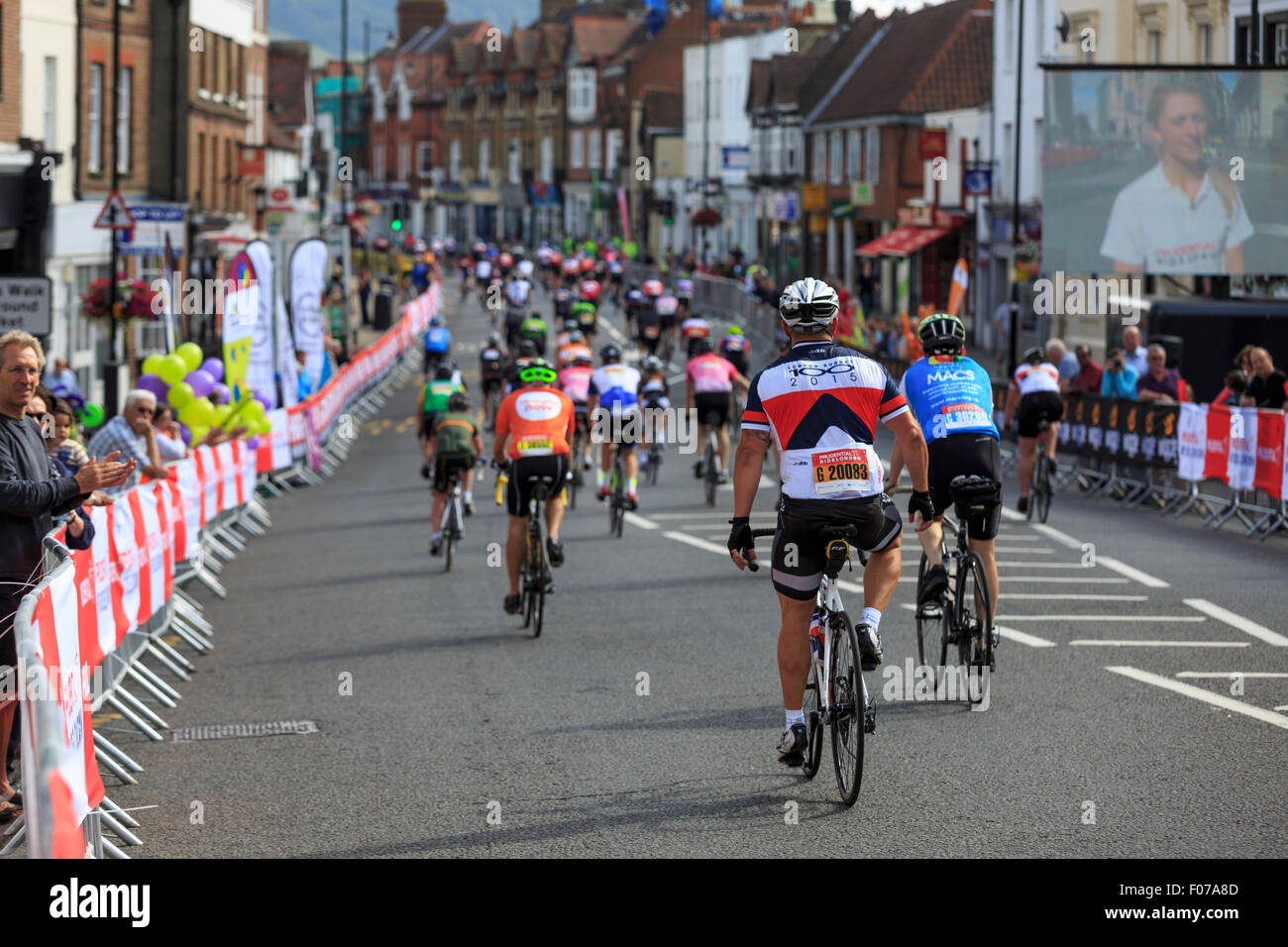 Amateur cyclists pass through Dorking town centre during the 2015 Prudential RideLondon-Surrey 100, a 100 mile cyclo-sportive Stock Photo