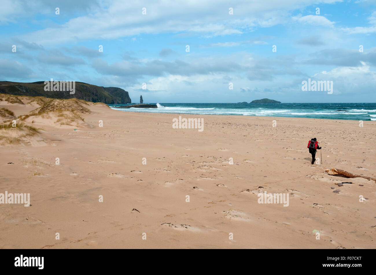 A walker on the beach at Sandwood Bay with the Am Buachaille sea stack