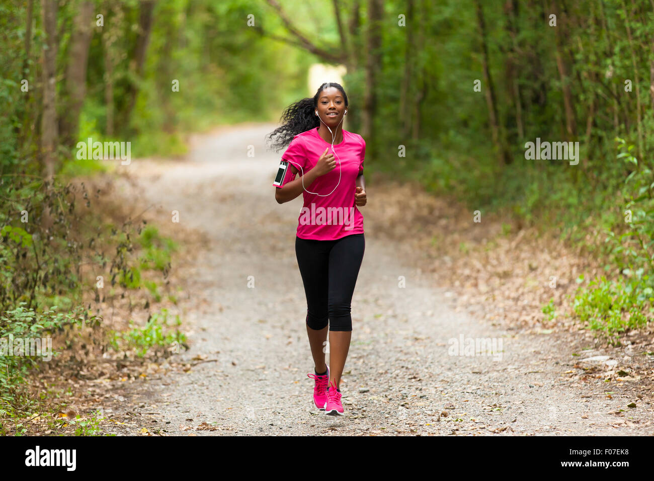 African american woman runner jogging outdoors - Fitness, people and healthy lifestyle Stock Photo