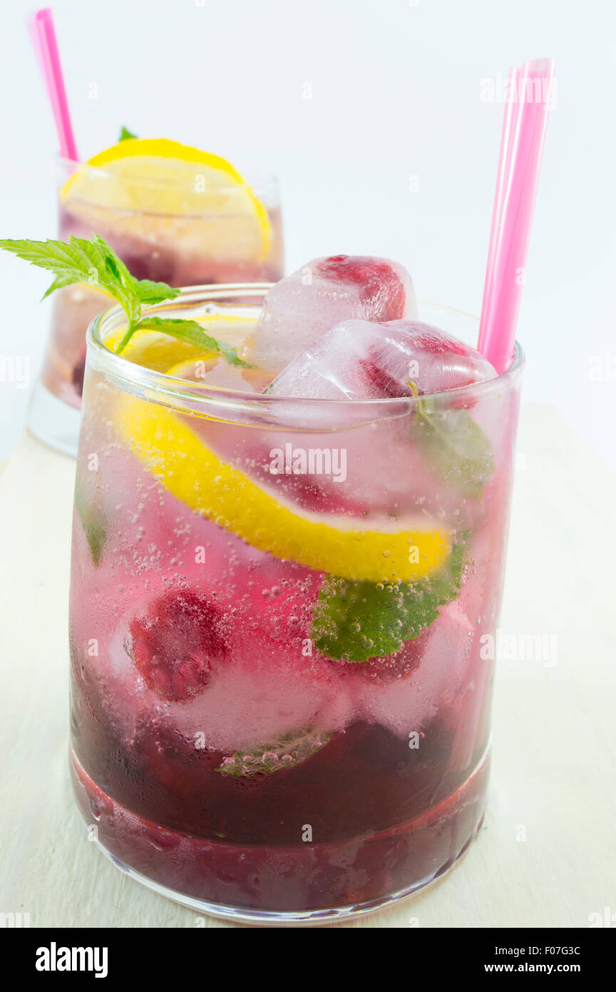 Natural homemade red forest fruit iced-T juice with ice, lemon and sliced fruits Stock Photo