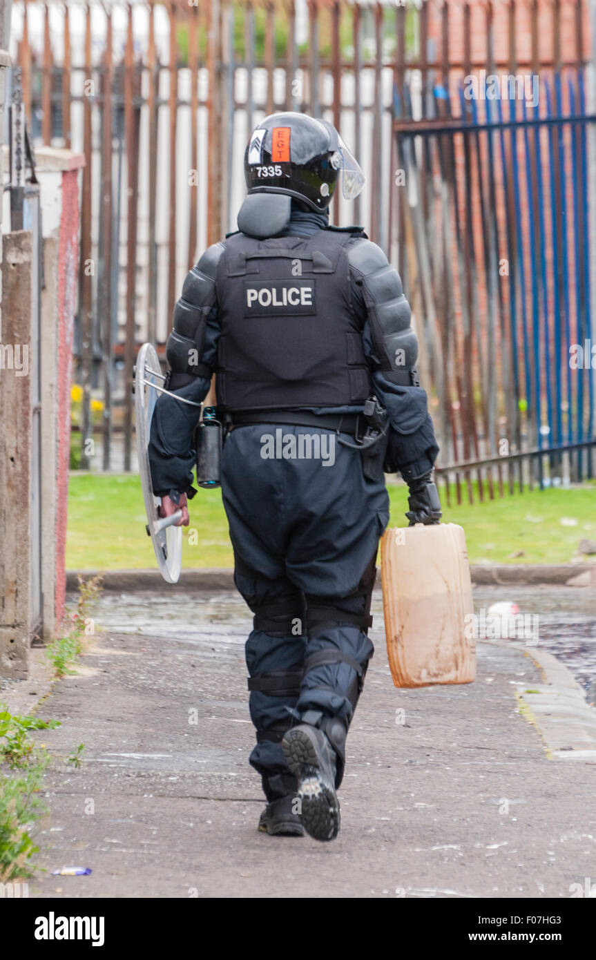 Belfast, Northern Ireland. 09 Aug 2015 - A PSNI sergeant carries away a drum of petrol, which was being used to make petrol bombs. Credit:  Stephen Barnes/Alamy Live News Stock Photo