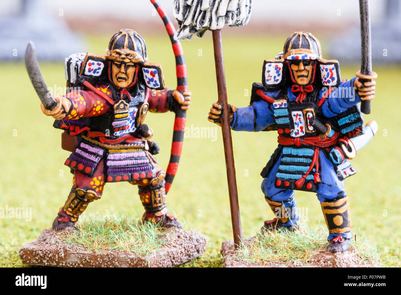 Close-up of metal painted model figures. Two Japanese samurai warriors, charging into battle, both holding swords. Table top war gaming. Stock Photo