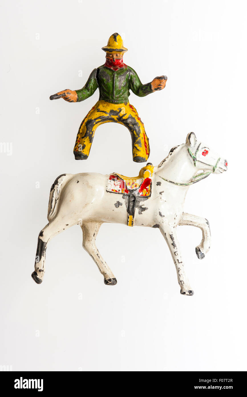 Timpo metal, lead, toy cowboy figure with horse, circa 1950. Cowboy above horse against plain white background. Stock Photo