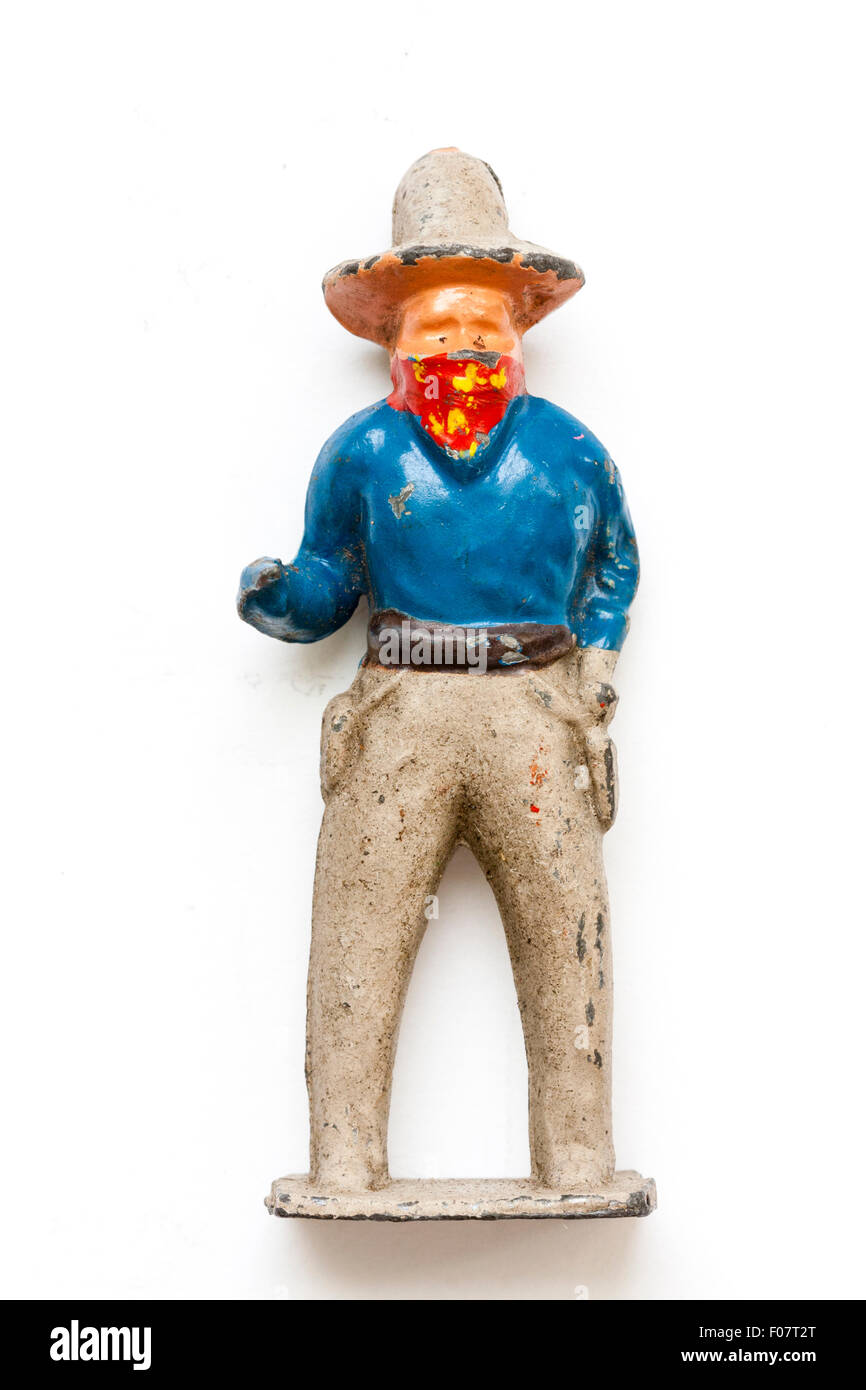 Crescent metal cowboy toy figure, circa 1950. A Bank robber holding gun (missing). Plain white background, neck tie covering face. Stock Photo