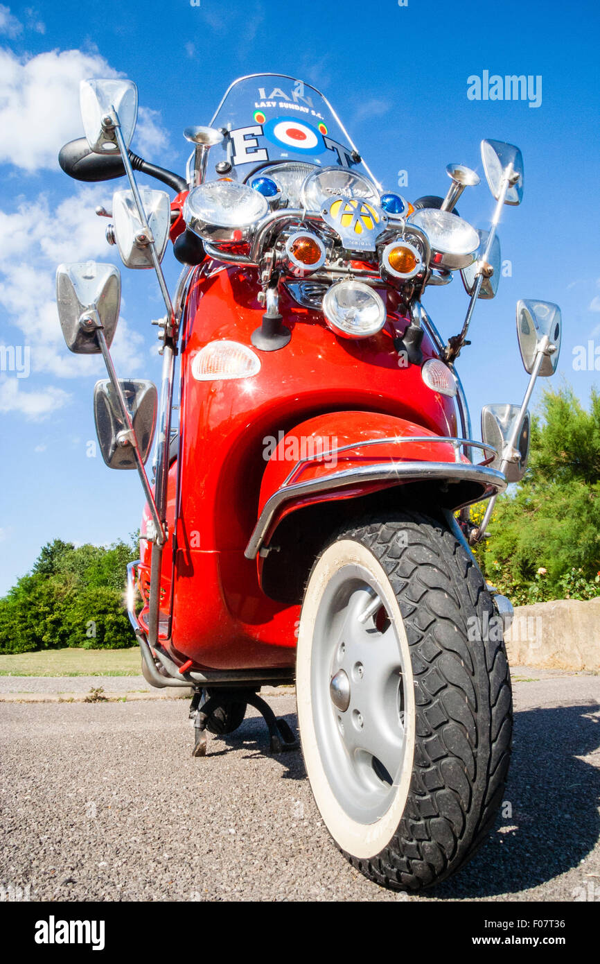 Motor Scooter, Italian Red Vespa ET4 125, modified, many wing mirrors as per Mods fashion cult look. Mirrors arranged around AA yellow badge. Stock Photo