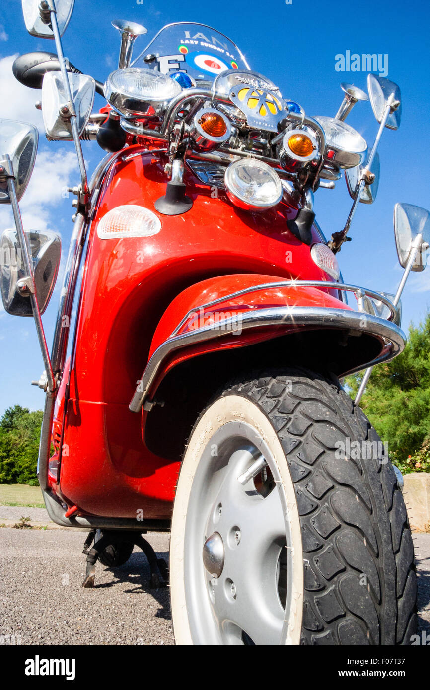 Motor Scooter, Italian Red Vespa ET4 125, modified, many wing mirrors as per Mods fashion cult look. Mirrors arranged around AA yellow badge. Stock Photo