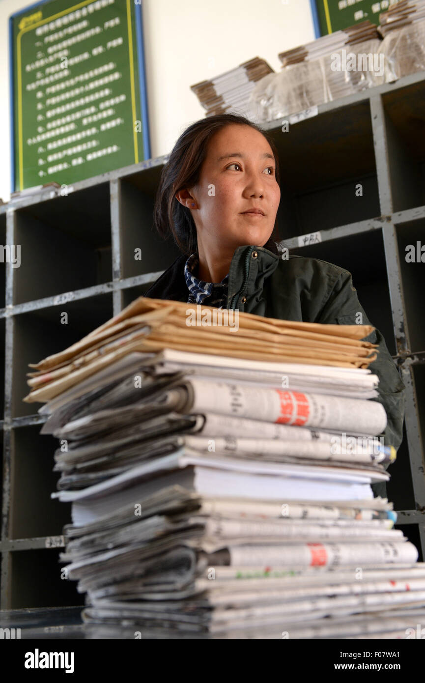 (150810) -- NYIMA, Aug. 10, 2015 (Xinhua) -- Mailwoman Bamu classifies newspapers and magazines in Nyima County of Nagqu Prefecture, southwest China's Tibet Autonomous Region, June 10, 2015. Bamu, a 26-year-old woman of Tibetan ethnic group, has been working as a mailwoman since 2006 for seven remote villages in Nyima County, which stands at an average of 4,500 meters above sea level and covers over 150 thousand square kilometers but has a population of less than 30 thousand. The farthest village is more than 100 kilometers away from the county town, and even some door-to-door dista Stock Photo