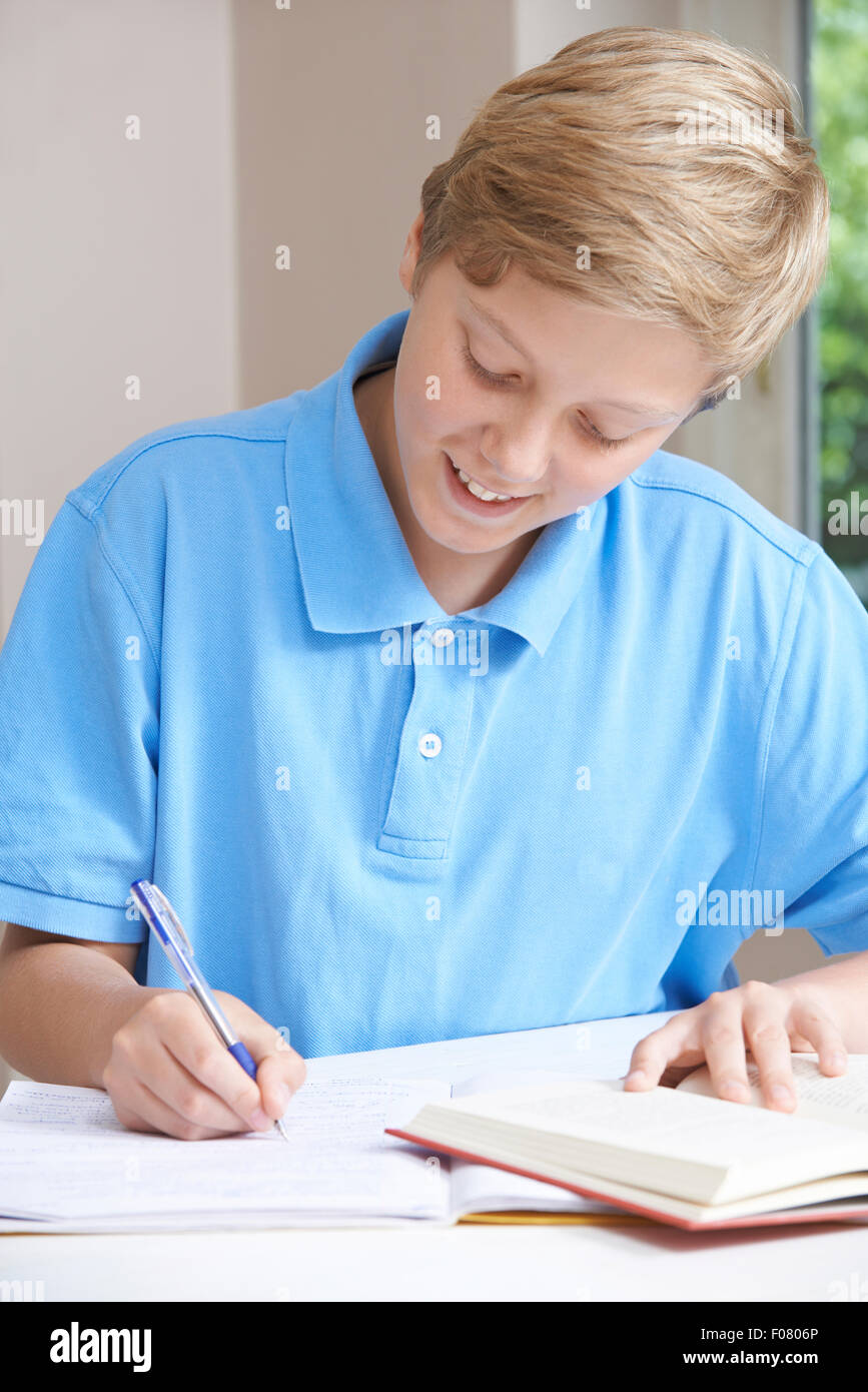 Teenage Boy Doing Homework At Table Stock Photo - Alamy