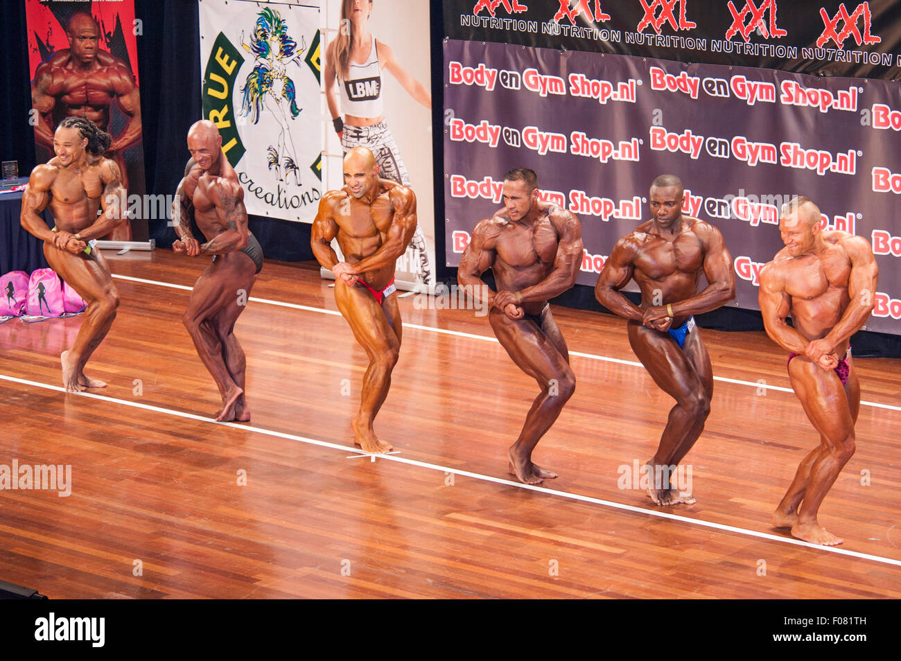 SCHIEDAM, THE NETHERLANDS - APRIL 26, 2015. Male bodybuilders showing their best chest pose on stage in a lineup comparison Stock Photo