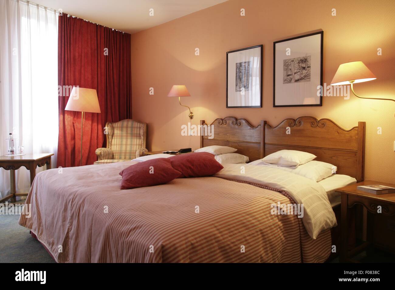 Bedroom with bed, cushion, chairs and table in hotel, Germany Stock