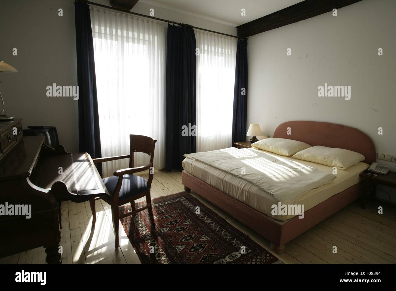 Bedroom with bed, chair and table in hotel, Germany Stock Photo Alamy