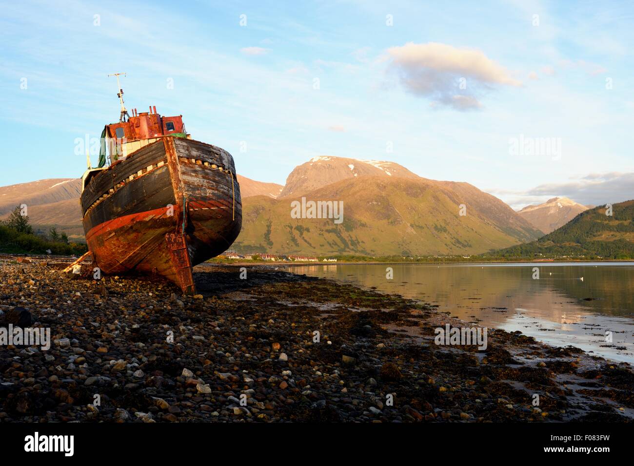 Wreck of a ship on the shores of Loch Linnhe at Corpach with Ben Nevis mountain behind, Scotland Stock Photo