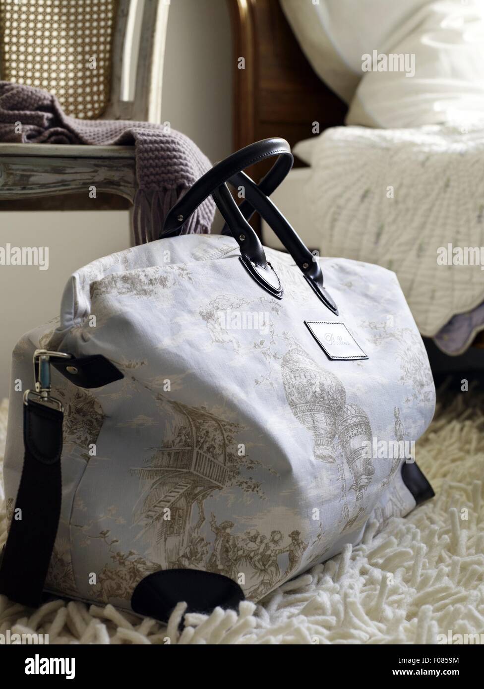 Close-up of white weekender bag with toile de jouy pattern and leather handles Stock Photo