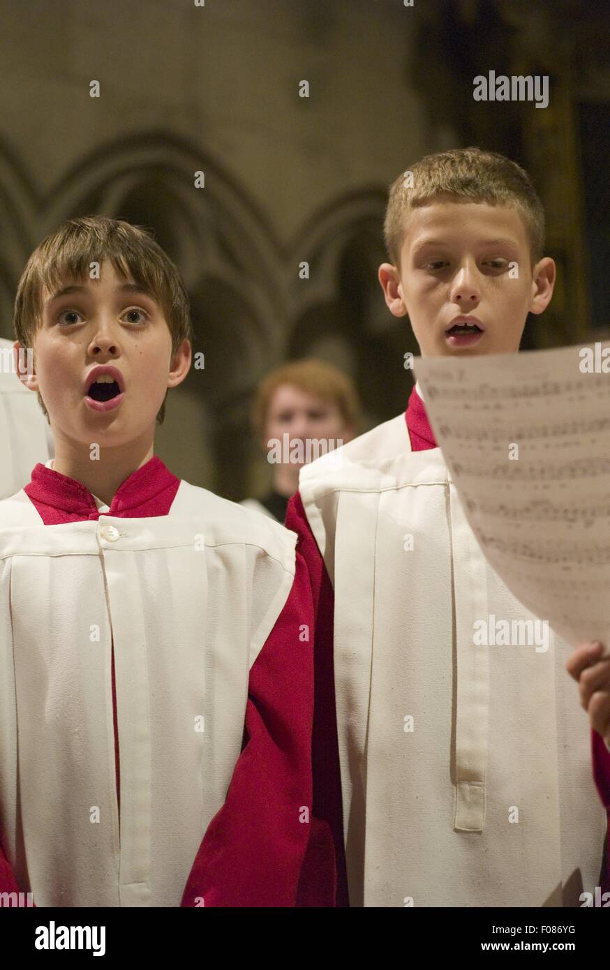 Choir boy's in red and white alter vestments singing in Cathedral Stock Photo