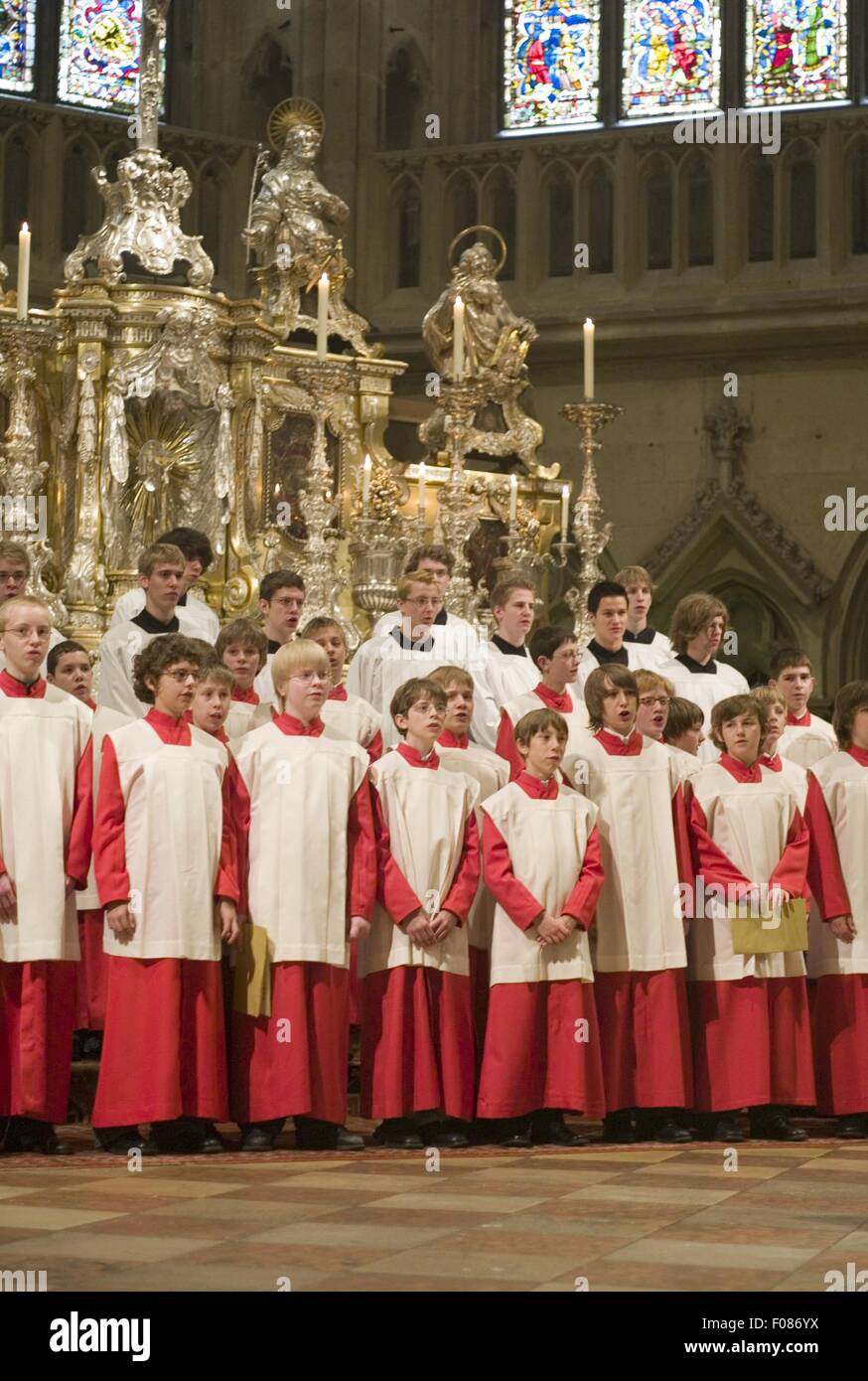 Choir boy's in red and white alter vestments singing in Cathedral Stock Photo